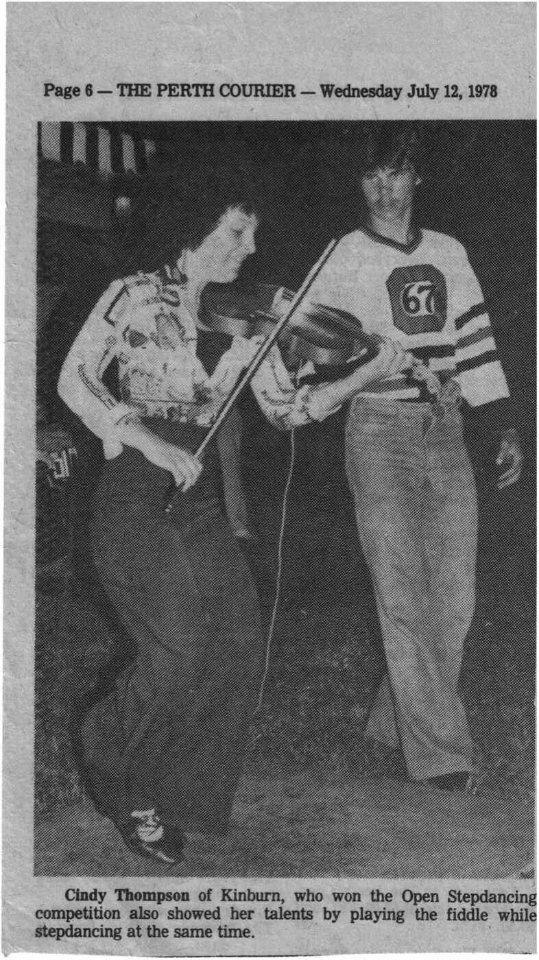 Newspaper clipping: Reggie Dumas and Cindy Thompson novelty fiddle.